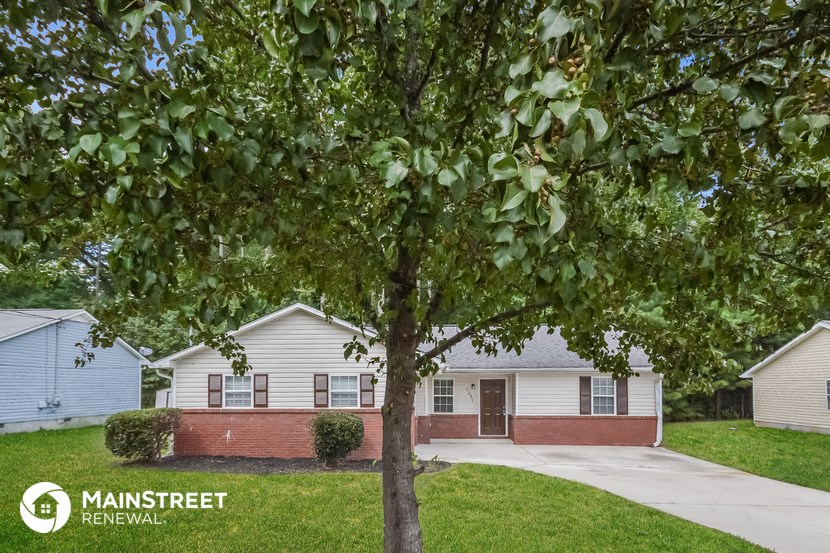 a white house with a tree in front of it