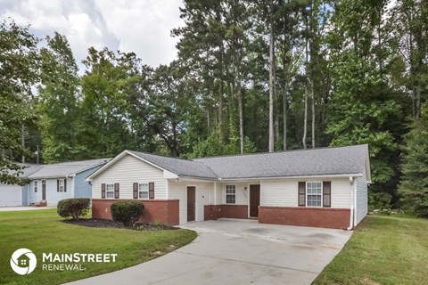 a white and with a driveway and trees