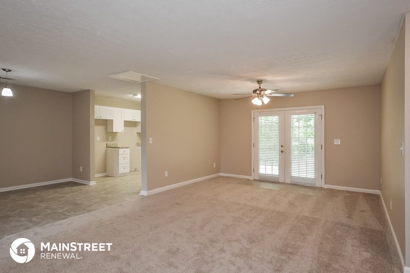 the living room of an empty house with a ceiling fan