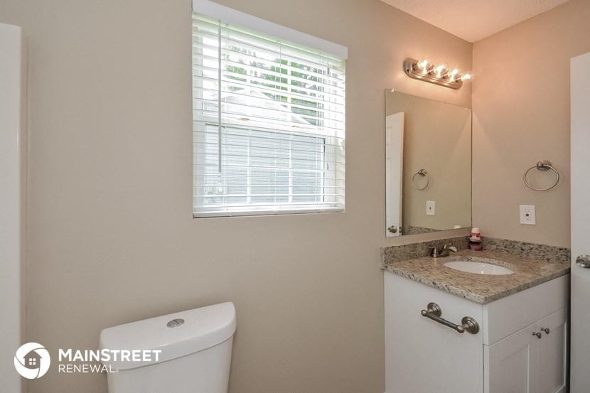 a bathroom with a toilet and a sink and a mirror
