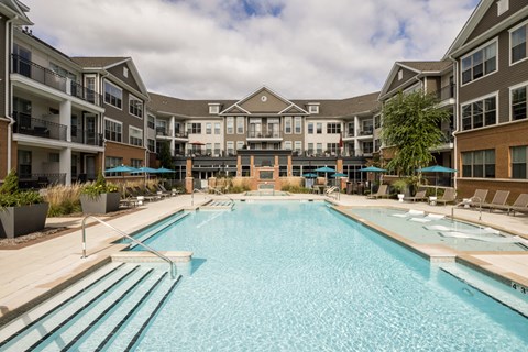 a swimming pool with an apartment building in the background