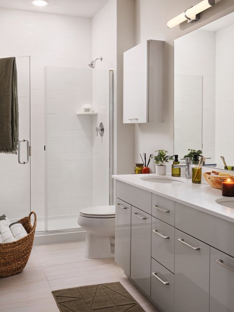 a white bathroom with a toilet and a shower