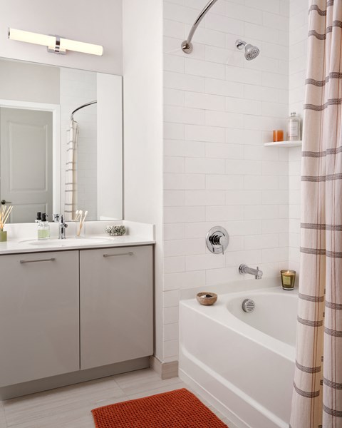 a white bathroom with a tub and a sink and a mirror