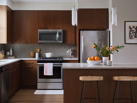 a kitchen with wooden cabinets and a counter with a sink and a refrigerator