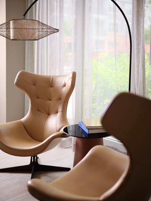 a living room with two chairs and a table and a floor lamp