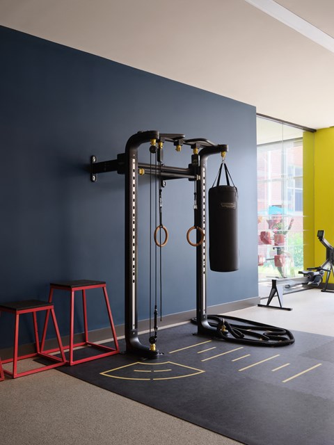 a boxing set up in a room with blue walls and red stools