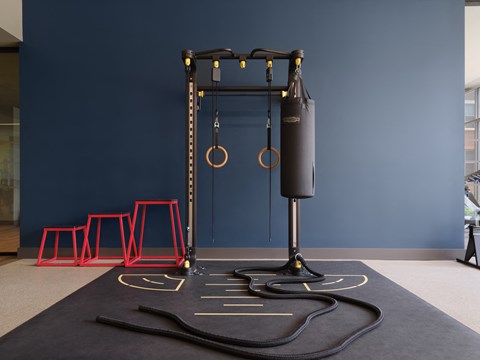 a swing set on a rug in a room with red stools
