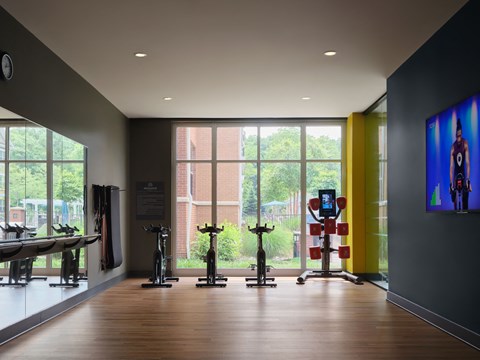 a fitness room with yoga machines and a large window