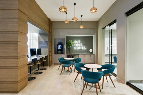 a lounge area with tables and chairs and a chalkboard on the wall