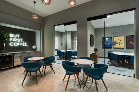 a room with tables and chairs and a chalkboard on the wall