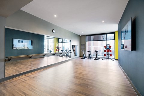 a gym with a hard wood floor and a large window
