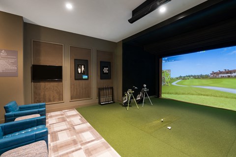 a room with a golf simulator and a view of a golf course