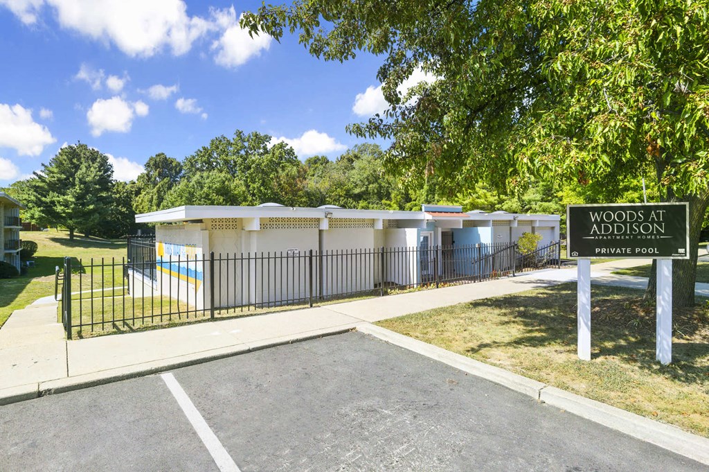 a sign in front of a fenced in area with toilets