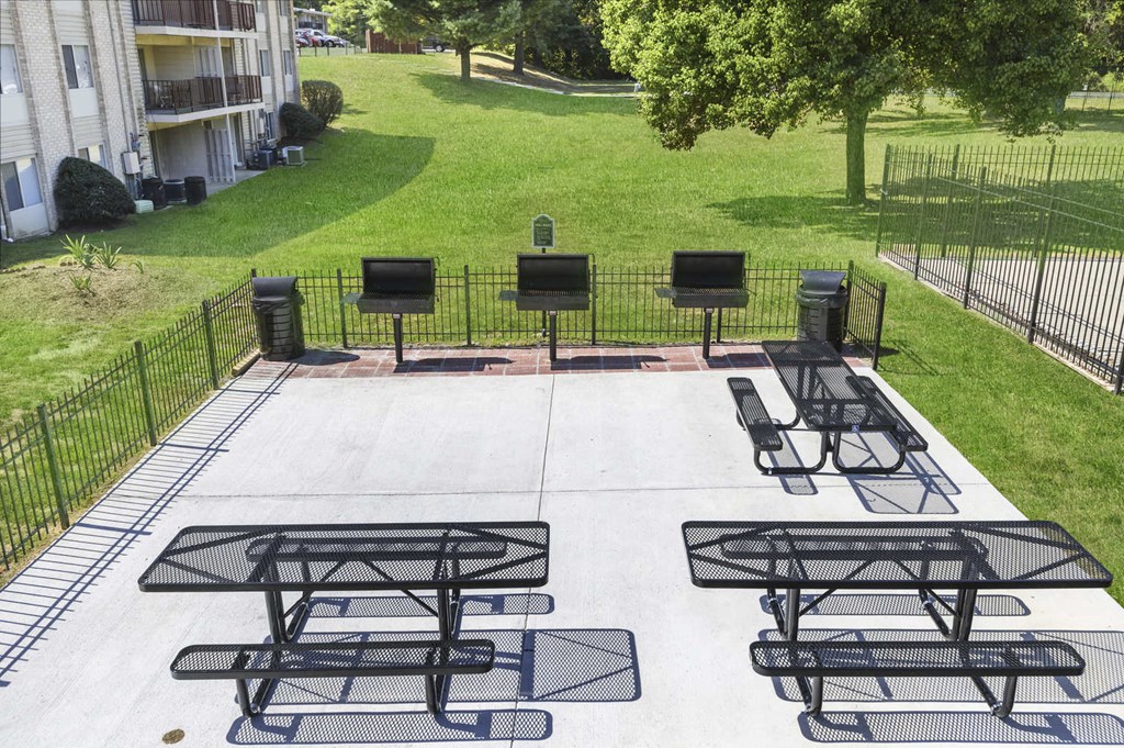 a patio with picnic tables and chairs in a park