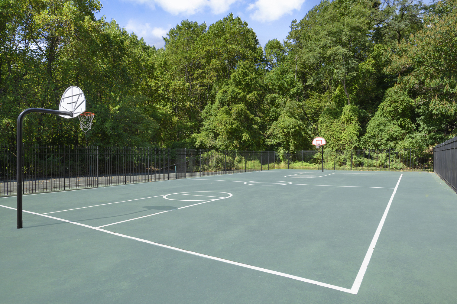 a tennis court with a basketball hoop and a net