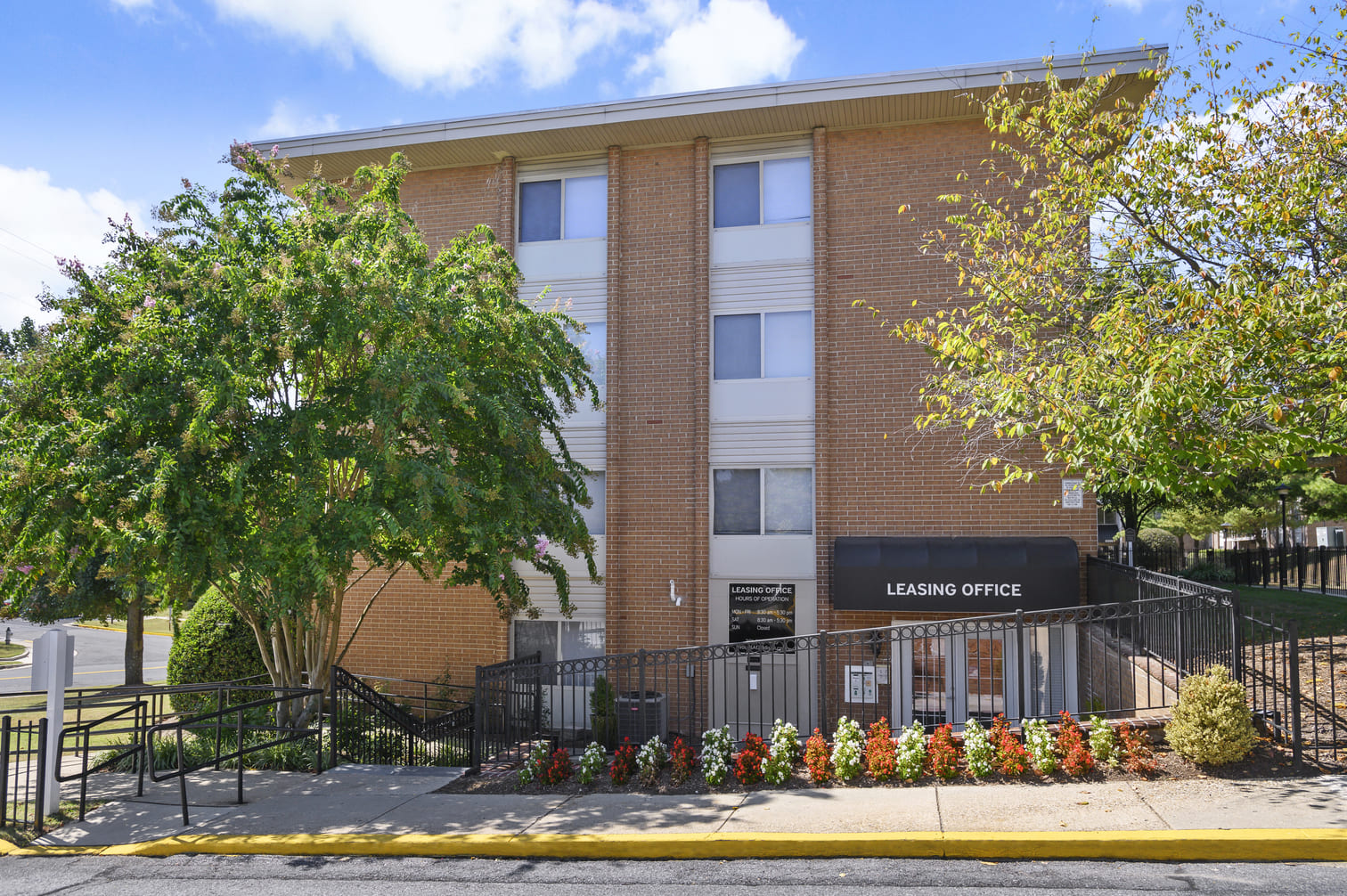 a brick building with a staircase and a tree in front of it
