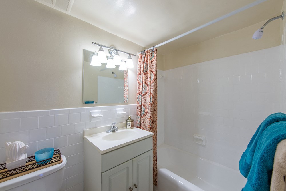 a bathroom with a sink and a tub and a shower curtain