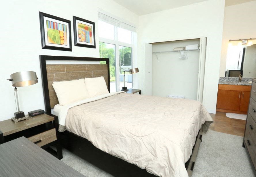 a bedroom with a large bed and a bathroom