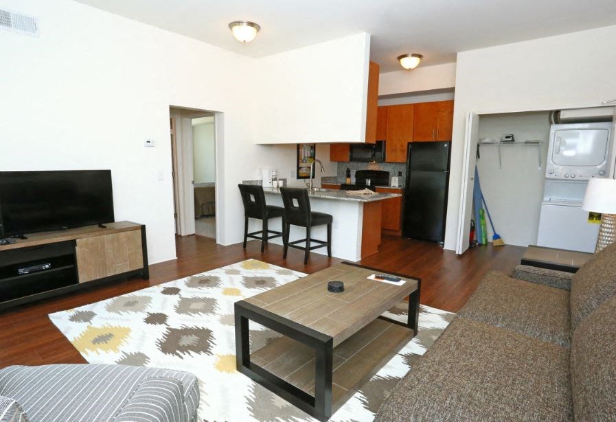 a living room and kitchen with a couch and a table