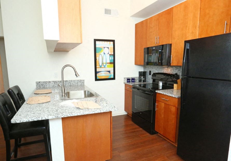 a kitchen with black appliances and a granite counter top
