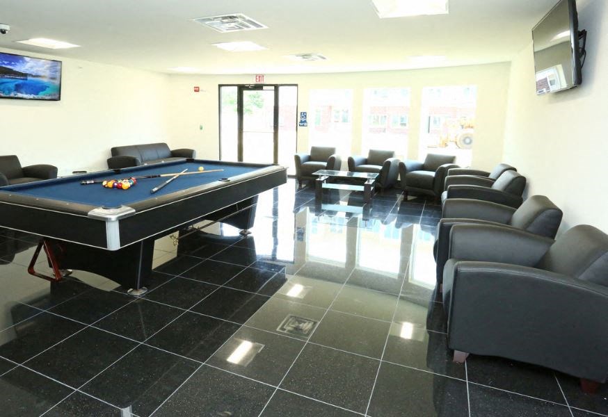 a game room with a pool table and chairs