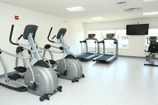 a gym with several exercise bikes and a television