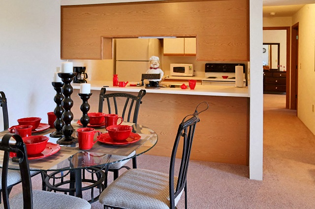 A kitchen with a table set for two.