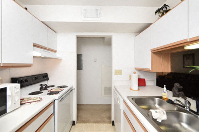 A kitchen with white cabinets and a black stove top.