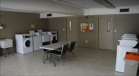 A laundry room with a table and chairs.