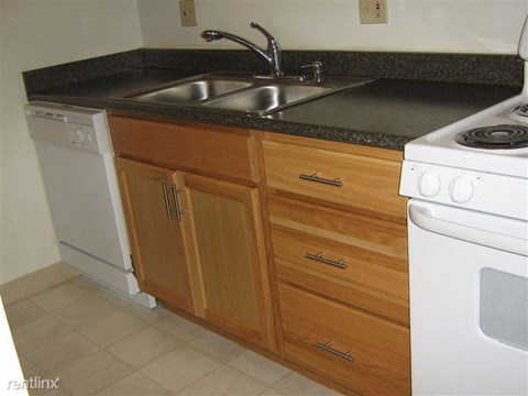 A kitchen with a white dishwasher and white stove.