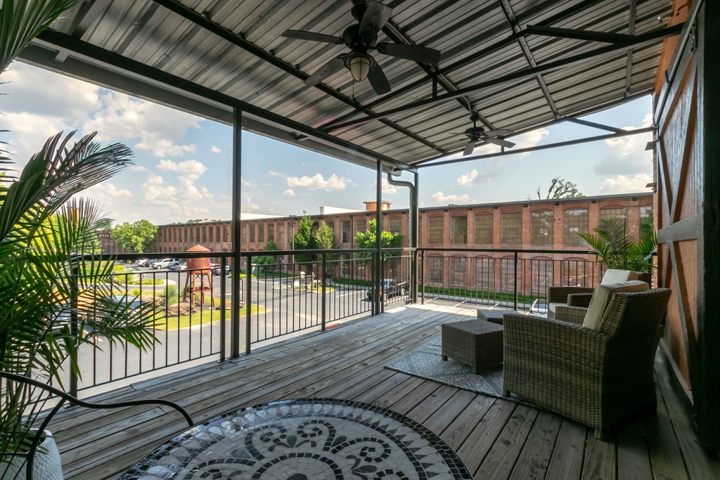 a patio with a deck and a building in the background