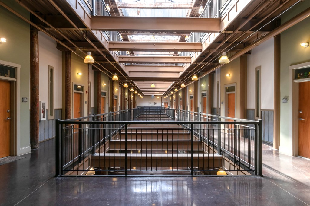 a large hallway with stairs and a glass ceiling