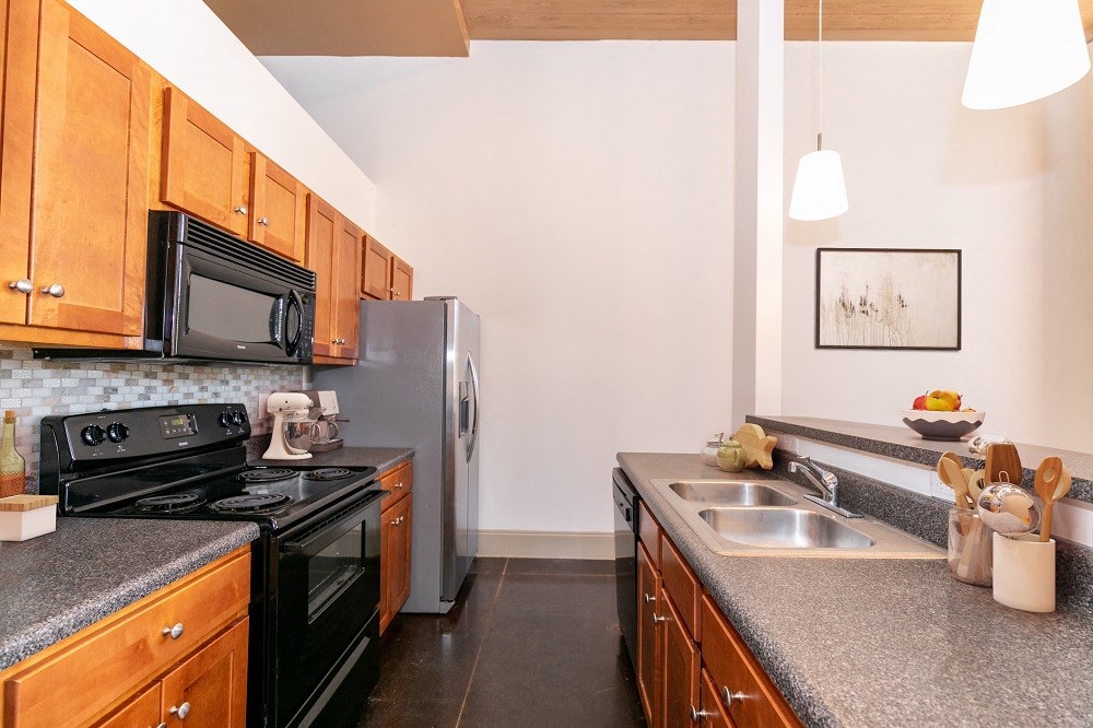 full kitchen with granite counter tops and stainless steel appliances and black appliances