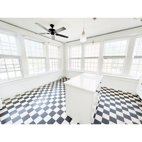 A room with a checkered floor and a ceiling fan.