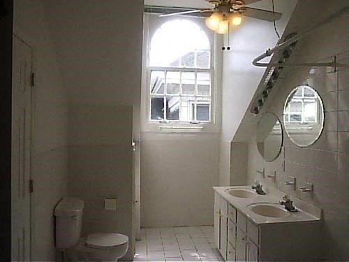 a bathroom with a toilet and a sink and a window