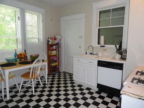 a kitchen with a checkered floor and a table and chairs