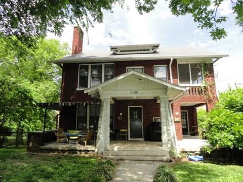 a red brick house with columns and a porch