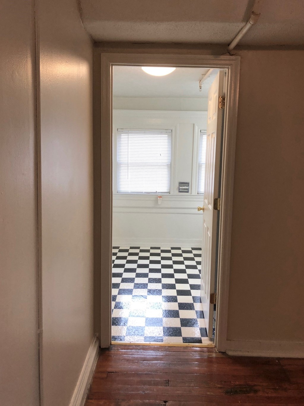 a room with a checkered floor and a window