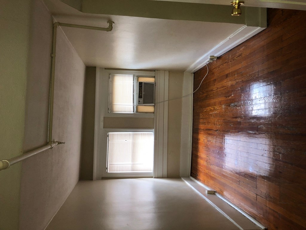 an empty room with a wooden wall and a window