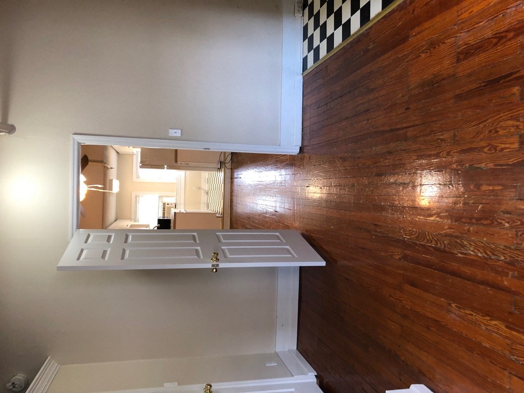 a kitchen with a white cabinet and a wood wall