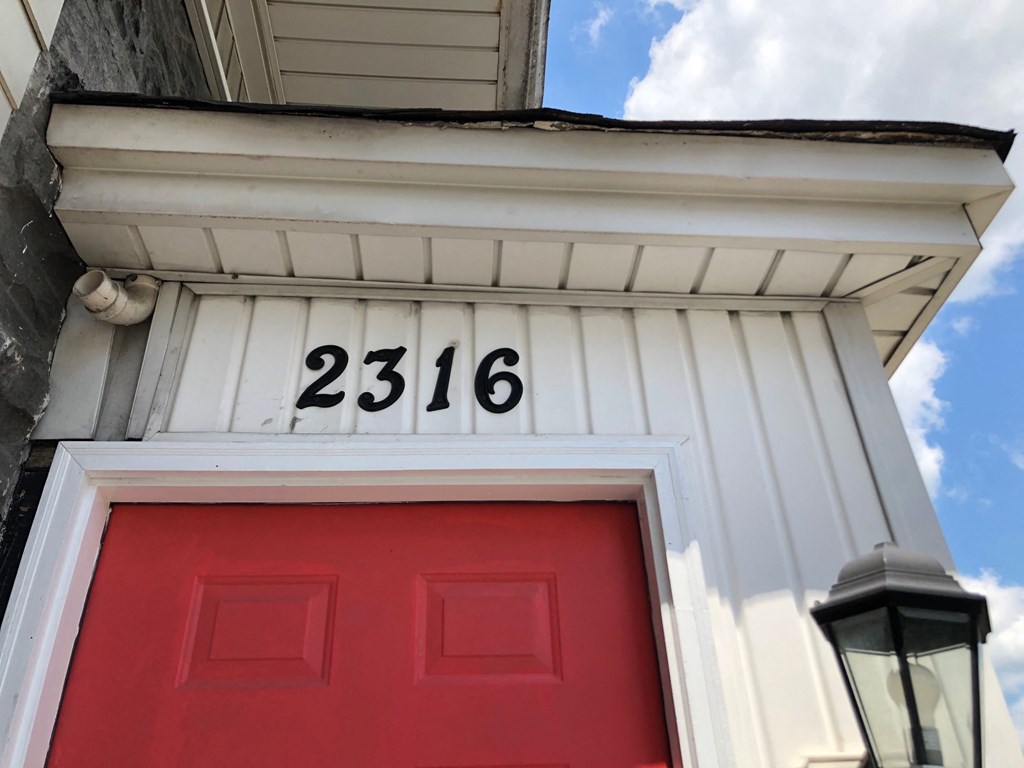 a red door with the numbers on it on a white building