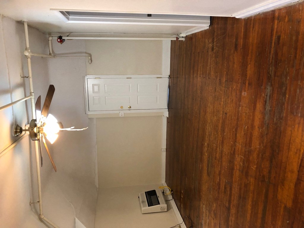 a room with a drywall wall and a closet and a light on the wall