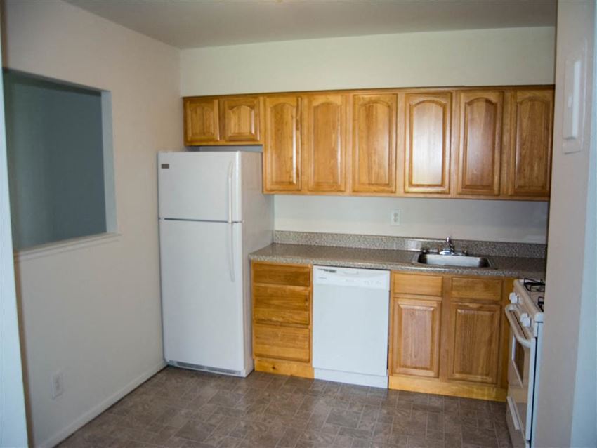 a kitchen with wooden cabinets and a white refrigerator