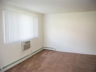 an empty room with a window and a heater