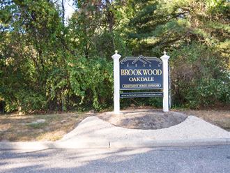 a sign for brookwood orchard at the side of a road