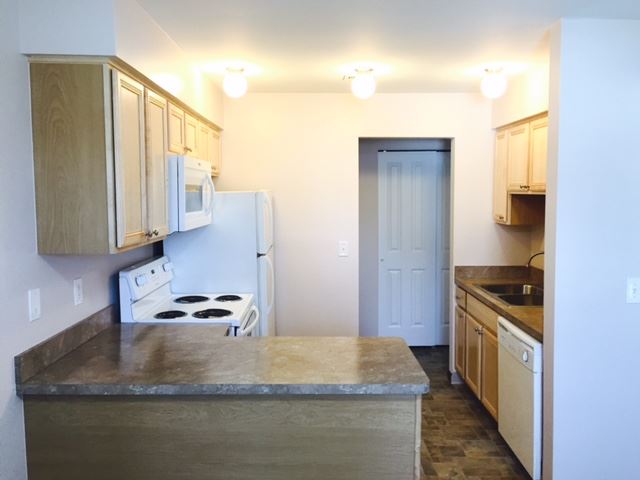 a kitchen with white appliances and wooden cabinets