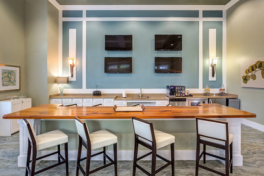 a kitchen with a bar and a counter top with chairs