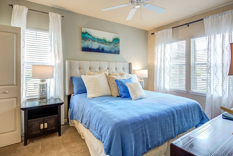 a bedroom with a large bed and a ceiling fan