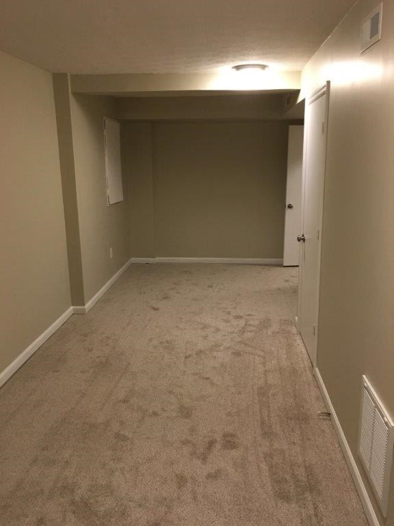 an empty room with a carpeted floor and a door