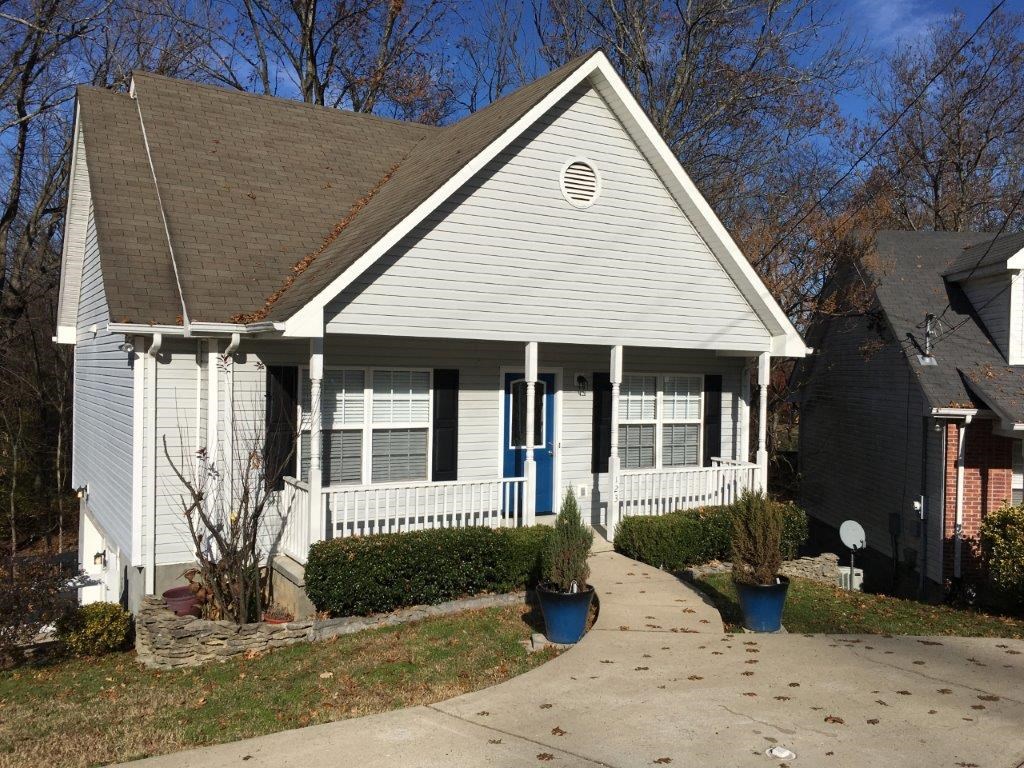 a white house with a porch and a sidewalk